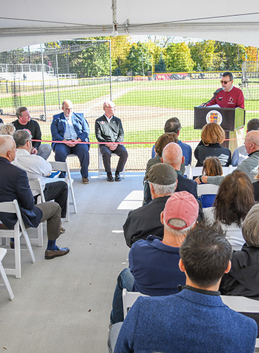A group of people gather together for the dedication of the player development center at Fisher.