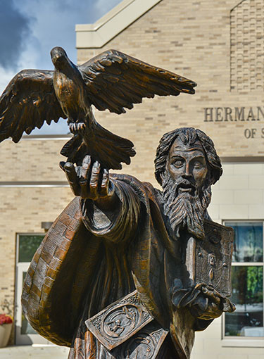 Bronze statue of St. Basil releasing a bird from his hand.