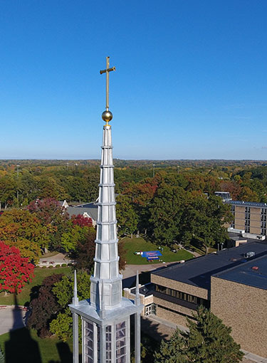 Aerial view of the Kearney Hall steeple against a blue sky.