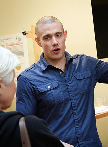 A student presents his research during a poster presentation.