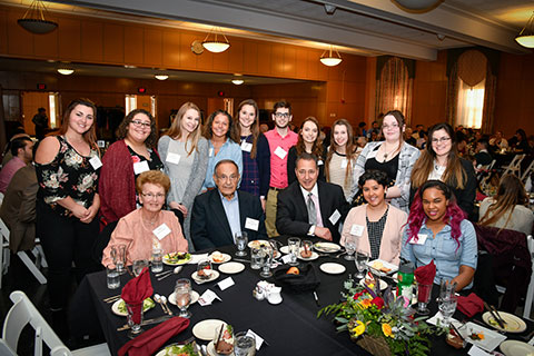 A group of students surround Charlie and Elaine Constantino at a scholarhip recognition event.