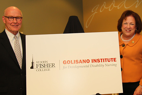 President Rooney is seen holding a sign while he announces the Golisano Institute for Developmental Disability Nursing.