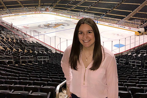 Emma Kilmer poses in the stands at the Pittsburgh Penguins stadium.